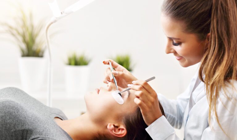 Lash artist applying lash extensions with eye pads