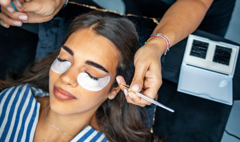 Eyelash extension procedure on beautiful woman with long eyelashes in a beauty salon