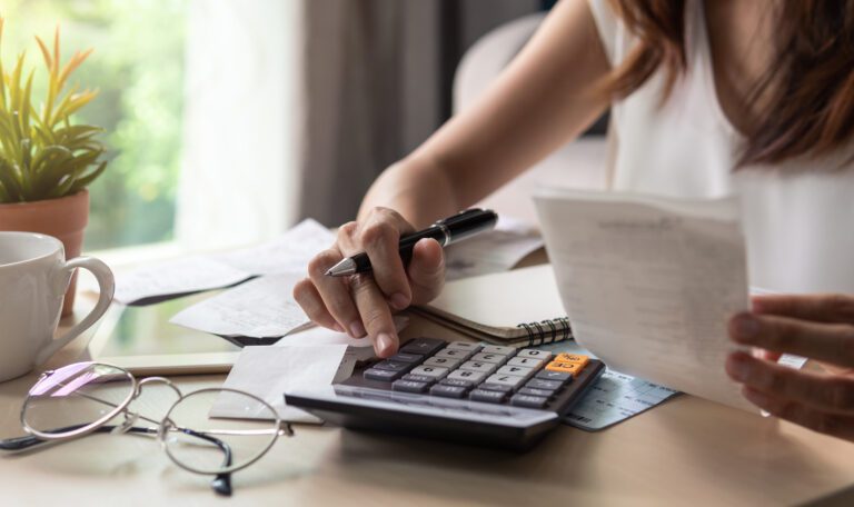 tressed young woman checking bills, taxes, bank account balance and calculating expenses in the living room at home