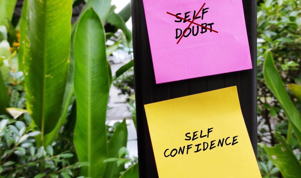 Pink and yellow notes with text SELF DOUBT - SELF CONFIDENCE, concept of to overcome SELF DOUBT from keeping you struck, get out of fear and regaining self-confidence